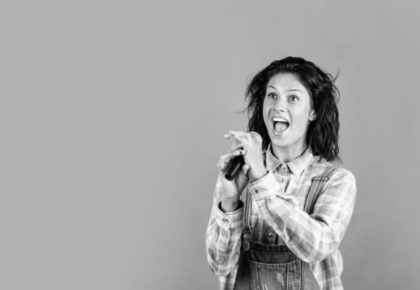 Glücklich hübsche Frau mit brünetten Haaren tragen lässige Kleidung singen Lied in Mikrofon, Kopierraum, Musik — Stockfoto