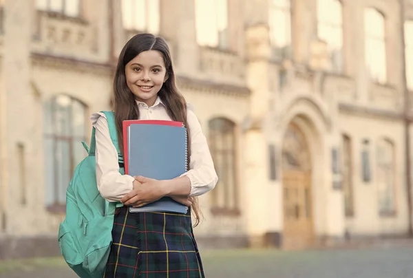Küçük kız öğrenci üniforması ve sırt çantası kitapları, bilgi günü konsepti. — Stok fotoğraf