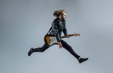 Modaya uygun çılgın adam. Müzik aleti. Deri ceketli duygusal sakallı rockçı.