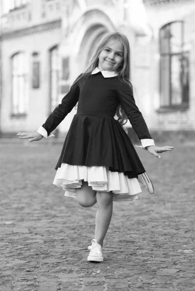 Bailarina de ballet pequeña feliz en equilibrio uniforme escolar en la pierna al aire libre, bailarina —  Fotos de Stock