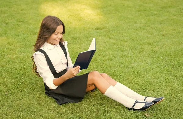 《骄傲的传统》用书努力工作的孩子。教育和阅读的概念。想象力的发展。可爱的女孩看书。快乐的学龄前女孩，校园里有一本书。回学校去 — 图库照片
