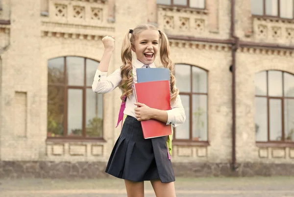 Dětská budoucnost. koncepce vzdělávání a čtení. rozvoj představivosti. Roztomilá holka drží zápisník. šťastná školačka na školním dvoře. Zpátky do školy. Tvrdě pracující dítě nosit batoh — Stock fotografie