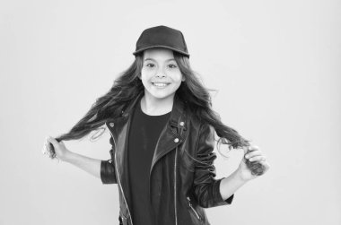 Havalı görünümlü mutlu küçük bir çocuk. Uzun esmer, sarı saçlı, saç stili.