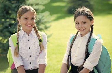 Resmi üniformalı mutlu çocuklar okul sonrası açık havada güneşli bir günün ve bilgi gününün tadını çıkarıyorlar.