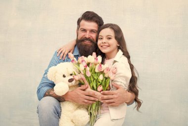 Ufaklık için harika bir hediye. Mutlu aile bayramı kutluyor. Küçük çocuk ve sakallı adam çiçek ve oyuncak tutuyor. Küçük kız babaya sarılıyor. Hediyelik eşya dükkanı. Oyuncakçı. Çiçek dükkanı. Doğum günü hediyesi