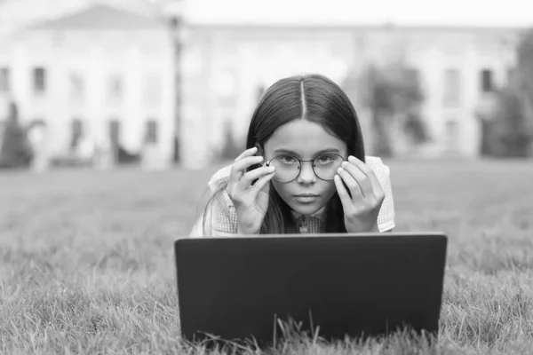 anti-reflective coating glasses. online education. back to school. teen girl use computer in park. child in glasses with notebook. new technology in modern life. serious kid work on laptop