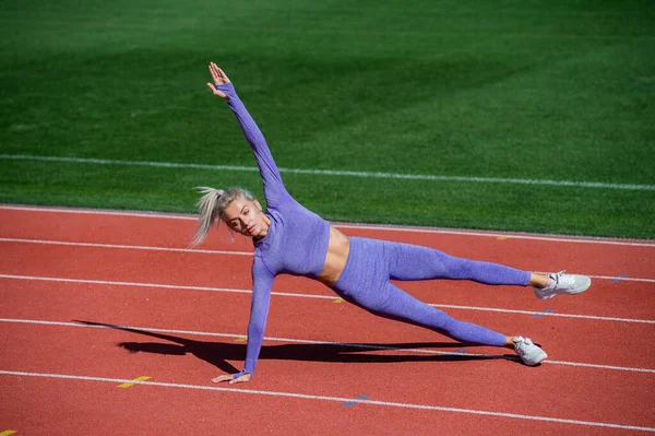 Sexy sportowe kobieta rozciągające i rozgrzewające się w odzież sportowa na stadionie działa utwór, zdrowy styl życia — Zdjęcie stockowe