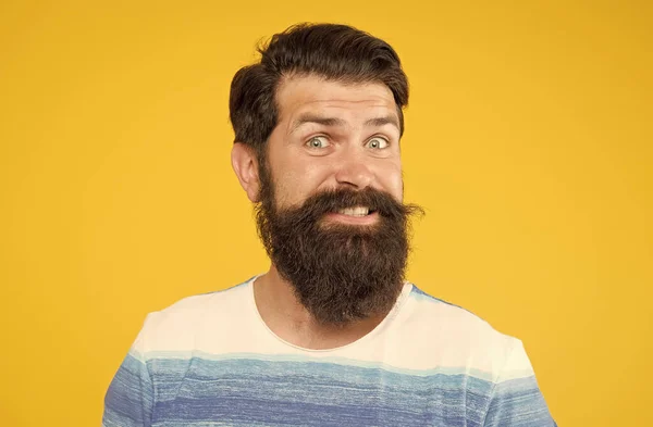 Macho com cabelo elegante. retrato de um homem barbudo brutal. homem elegante engraçado sorrindo. homem barbudo brutal feliz no fundo amarelo. homem confiante bonito tem penteado perfeito. cuidado facial masculino — Fotografia de Stock