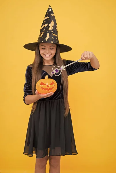 Halloween tiener meisje in heks hoed houden toverstaf en pompoen jack o lantaarn voor hekserij, gelukkig halloween — Stockfoto