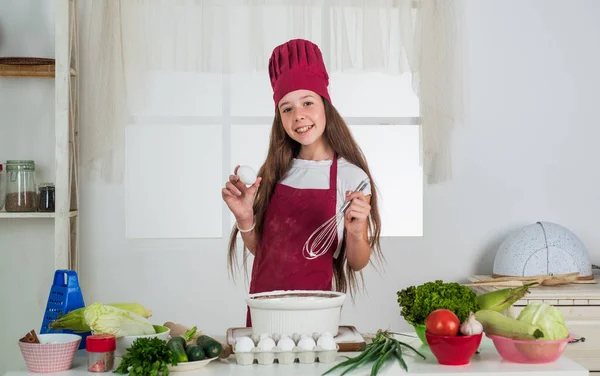 Great food. housekeeping and home helping. childhood development. small girl baking in kitchen. kid chef cooking with beater and egg. child prepare healthy food at home and wearing cook uniform — 스톡 사진