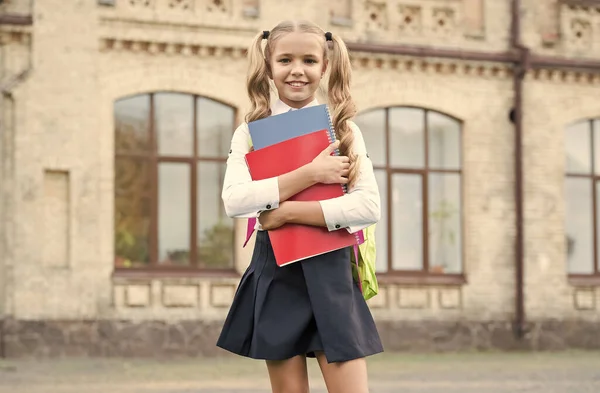 Sich in der Bildung engagieren. kleines Mädchen hält Buch. Literatur für Kinder. Kindheit im Werden. Arbeit mit Notizbuch. zurück zur Schule. Kind mit Schultasche. Lächelndes Kind mit Rucksack. Lasst uns Hausaufgaben machen — Stockfoto