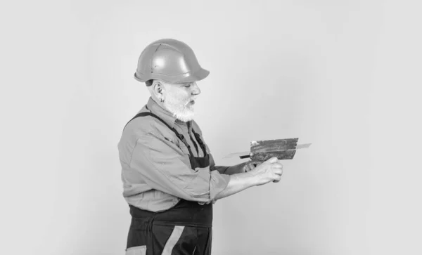 Ele precisa de uma pausa. Estucador em gesso uniforme de trabalho. homem com espátula. processo de aplicação camada de massa de vidraceiro. Ferramentas de reboco para gesso. espátula de gesso na placa de gesso drywall — Fotografia de Stock