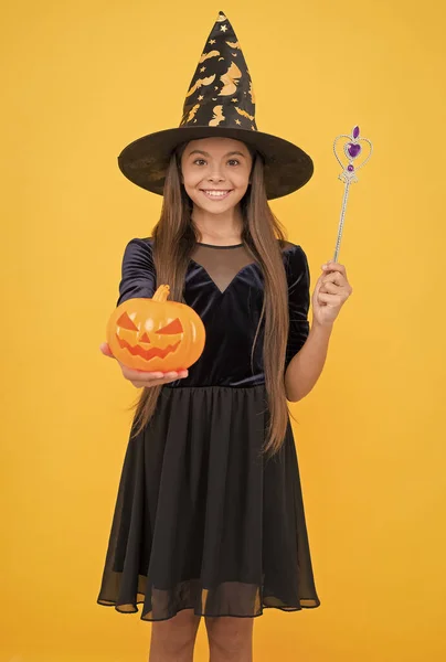 魔術と魔法だ。子供の秋の休日。お祝いの準備ができて10代の女の子。コスチュームパーティーの楽しみ。ハッピーハロウィーン。魔女の帽子の子供。子供は魔法の杖と不気味なカボチャを持っています。幽霊がここに集まる — ストック写真