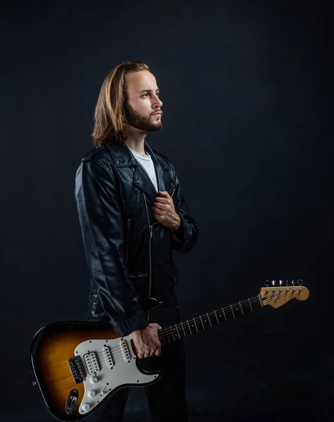 Músico de rock barbudo tocando guitarra elétrica em jaqueta de couro, estrela de rock — Fotografia de Stock