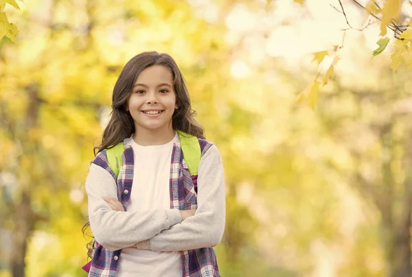 Idealny jesienny dzień uśmiechniętego dziecka z torbą szkolną w jesiennym parku przy dobrej pogodzie, czas szkolny — Zdjęcie stockowe