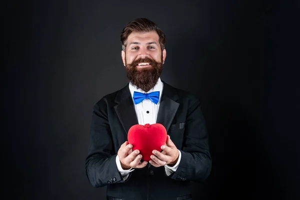 Feliz smoking homem com barba segurar romântico amor coração, feliz dia dos namorados — Fotografia de Stock