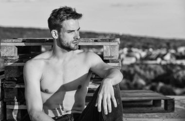 Zihnini boşalt. Gün batımında kaslı bir adam. Maço adamın çıplak gövdesi var. Kot pantolon giymiş seksi bir adam. Gökyüzü arka planında erkek manken. Yaz, açık havada dinlenmek. Atletik sporcunun seksi bir vücudu var.