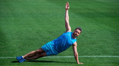 Sporcu kaslı adam antrenmandan önce ısınıyor, ısınıyor.