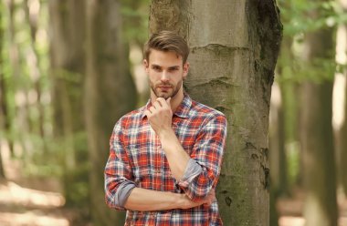 Ciddi bir adamın orman geçmişi ve berber dükkanında iyi bakımlı saçları var.