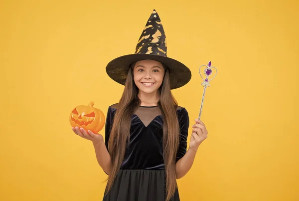 My weapon. carnival costume party. trick or treat. celebrate the holidays. jack o lantern. halloween witch girl. happy childhood. child in witch hat with pumpkin. kid create miracles with magic wand — Stock Photo, Image