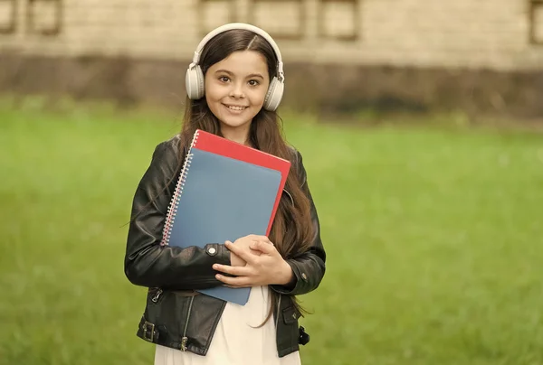 Дівчина слухає аудіо-підручники на шляху до школи, концепція мовних уроків — стокове фото