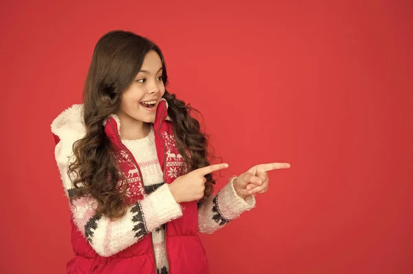 Веселий ідентифікатор вказує палець на місце для копіювання в теплому зимовому одязі на новорічні канікули, продаж зимових покупок — стокове фото