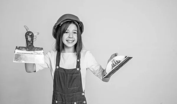 Menina criança em chapéu duro no local de construção usar espátula, equipamentos — Fotografia de Stock