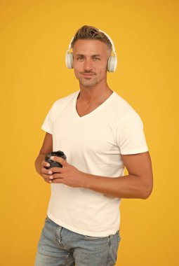 Kafein tüketimi. Orta yaşlı bir adam kahve fincanı tutuyor. Kafein bağımlısı. Doğal bir uyarıcı. Antioksidan ve yararlı besinler. Paket servis içkisi. Müzik teknolojisi. Modern yaşam tarzı