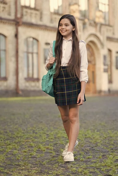 Little girl formalny styl mundur i plecak w podwórku szkolnym, koncepcja szkoły publicznej — Zdjęcie stockowe