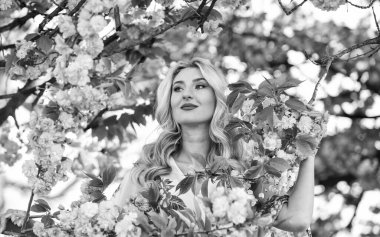 Bahar sembolü Kız bahçedeki sakuranın tadını çıkarıyor. Çiçeklerin kadınları neden her zaman mutlu ettiğini. Mutlu bahar günleri. Uyum ve kadın enerjisi. Kiraz ağacı. İyi titreşimler. Çiçek aroması. Bahar çiçekli ağaç