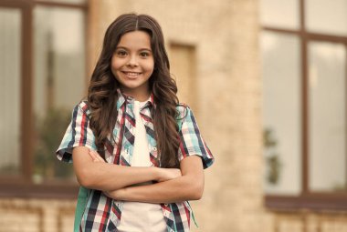 Kendinden emin ve keyifli. Kendine güvenen çocuk kollarını açık havada çapraz tut. Moda kızının kendine güveni tam. Sıradan moda trendi. Modayı takip eden çocuklar giyer. Çocuk kıyafetleri. Geleceğe güven, boşluğu kopyala