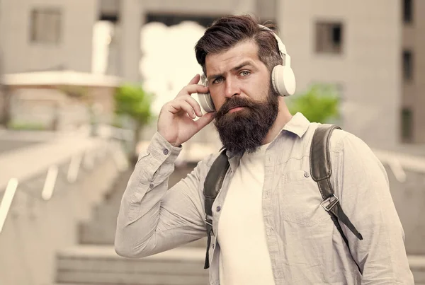 Daily route to work. Modern life. Man with headphones walking city center. Listening music. Handsome hipster with backpack walking street. Walking through empty streets. Alone with music. Good sound — Stock Photo, Image