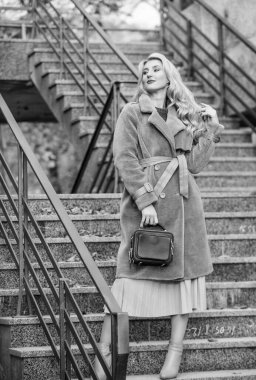 Rahat ve güzel hissetmek için sonbahar kıyafeti yap. Sonbahar kıyafeti. Kadınlar şık kıyafetler giyer ve çanta taşırlar. Modern sıcak ve şık eko kürklü giysi. Kız ceketi, şehir merdiveni arka planı.