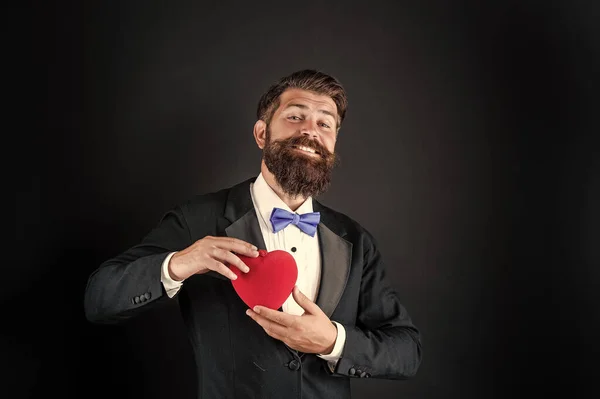bearded man in formal tuxedo with bow tie share love heart at 14th february valentines day, love