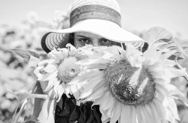 Küçük kız kırsal tarzda ayçiçeklerinin arkasına saklanıyor, saklambaç oynuyor.