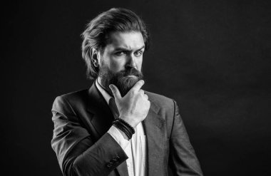 Pahalı takım elbiseli yakışıklı ve başarılı bir adam. Elli saati olan tişörtlü adam. Takım elbiseli başarılı bir adam. İş adamı takım elbise giyer. Resmi ofis hayatı. Ciddi sakallı adam.