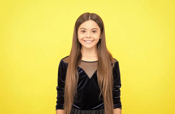 Happy child smile with long brunette hair in fashion dress yellow background, childhood — Stock Photo, Image