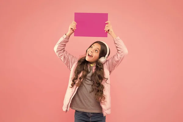 Was ist das? Online-Bildungsankündigung. Werbetechnik. Kindheitsentwicklung. Überraschte Kinder mit Kopfhörern hören Musik. zurück zur Schule. Kind hält leeres Papier für Kopierraum — Stockfoto