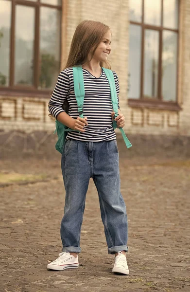 Criança feliz em estilo casual de moda levar saco escolar ao ar livre, escolaridade — Fotografia de Stock