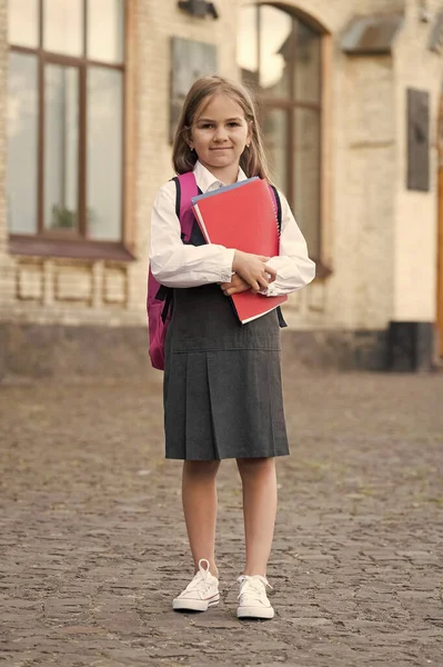 Criança pequena com volta para a escola olhar transportar mochila segurando livros, lição de casa — Fotografia de Stock