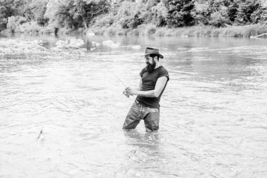 Balık tutmak eğlencelidir. Balıkçı ekipmanlarıyla. Fisher hafta sonu aktivitesi. Balık oltaya geldi. Vahşi doğada eğlence. Balıkçılık erkek hobisi. Zalim adam lastik çizme giyer Nehir suyunda durur