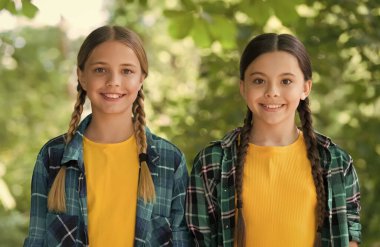 Sıcak bir gülümseme. Kot pantolon giyiyordu. Kızlar birlikte vakit geçirip eğleniyorlar. Çocukluk yaşam tarzı konsepti. Birliktelik. Mutlu çocuklar günü. Komik zaman harcaması. Neşeli kızlar en iyi arkadaşlar