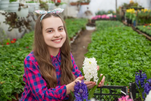Щаслива дівчина-підліток флорист догляд за рослинами горщиків в теплиці, домашня посадка — стокове фото