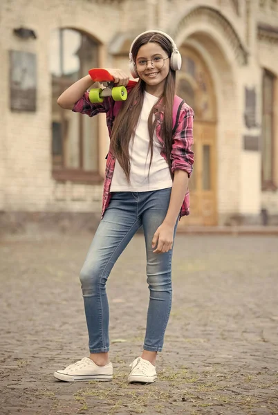 Mezclar vacaciones con rollo urbano. Niño feliz mantenga penny board al aire libre. Skateboarding. Viaje de patinaje. Libertad y ocio. Actividades de vacaciones. Vacaciones de verano — Foto de Stock