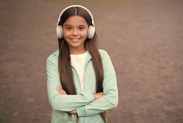 Alegre niño usar auriculares con música canción al aire libre disfrutando de la melodía, educación elearning — Foto de Stock