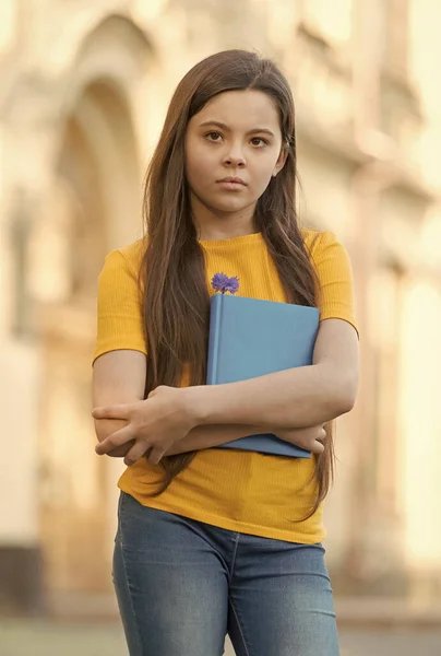 Menina criança de volta à escola segurar livro didático, knowldge conceito dia — Fotografia de Stock