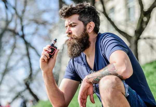 Homem barbudo a fumar vape. Fumar cigarro electrónico. Dispositivo de fumar. Homem barba longa relaxado com hábito de fumar. Um homem com barba exala fumo. Nuvens de fumo aromatizado. Conceito de alívio do estresse — Fotografia de Stock