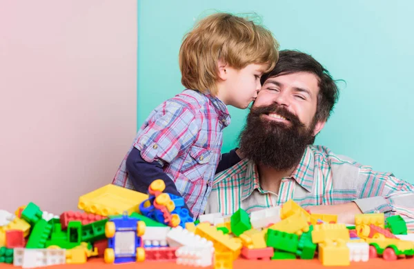 Dia dos pais. O hipster barbudo e o rapaz brincam juntos. Pai e criança construção de blocos de plástico. Conceito de cuidados infantis. Família feliz. Desenvolvimento e educação infantil. Pai e filho se divertir com tijolos — Fotografia de Stock