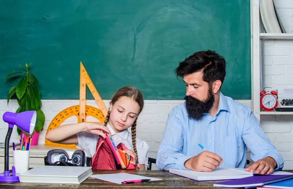 What is insedi. daughter study with father. Teachers day. knowledge day. Home schooling. back to school. Private teaching. small girl child with bearded teacher man in classroom. private lesson — Stock Photo, Image