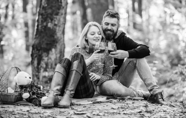 Romantisk picknick med vin i skogen. Par i kärlek fira årsdagen picknick datum. Par som kramas och dricker vin. Njuter av deras perfekta dejt. Glad kärleksfull par avkopplande i parken tillsammans — Stockfoto